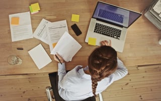 Businesswoman-working-at-her-office-desk-with-documents-and-laptop-000031045570_Large.jpg