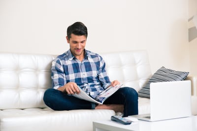 Portrait of a man reading magazine on the sofa at home-1